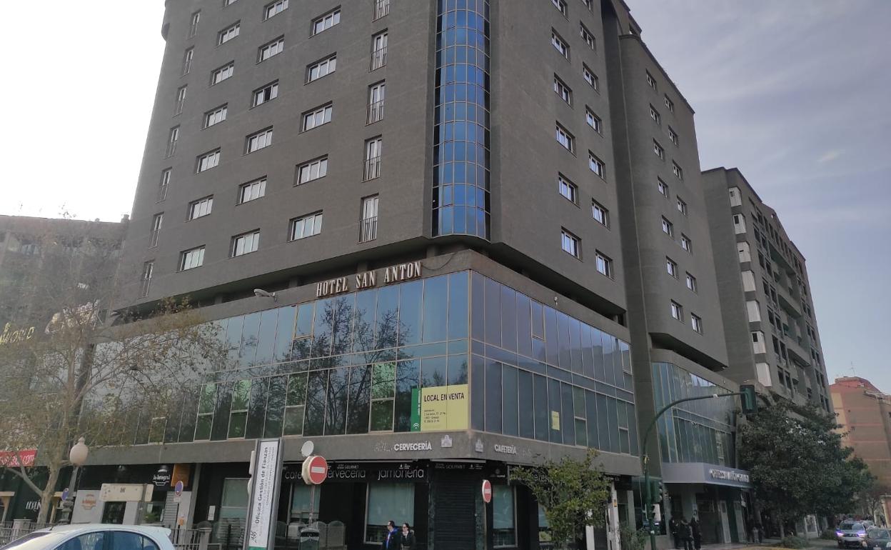 El edificio del hotel con un cartel que anuncia su venta.
