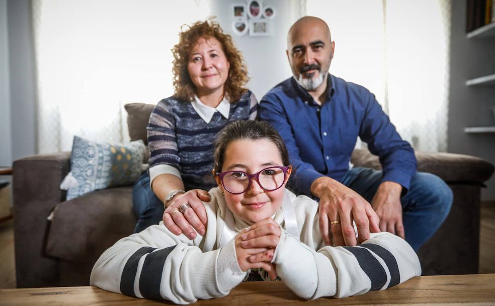 Raquel, de nueve años, con sus padres, Mercedes y Javier. La pequeña tiene las manos vendadas por una caída reciente.