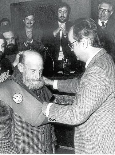 Reina recibe la banda de manosdel rector José Vida Soria. 