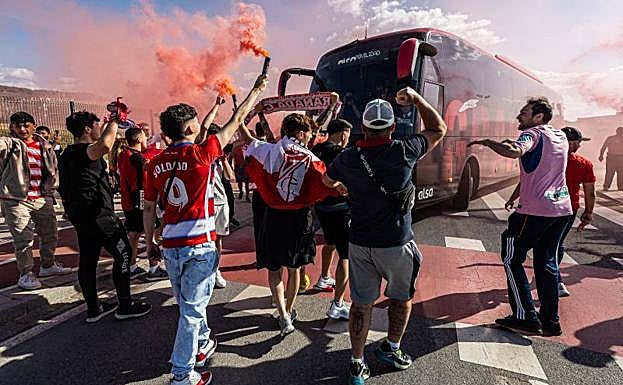 Los seguidores del Granada despiden al autobús del equipo entre botes de humo. 