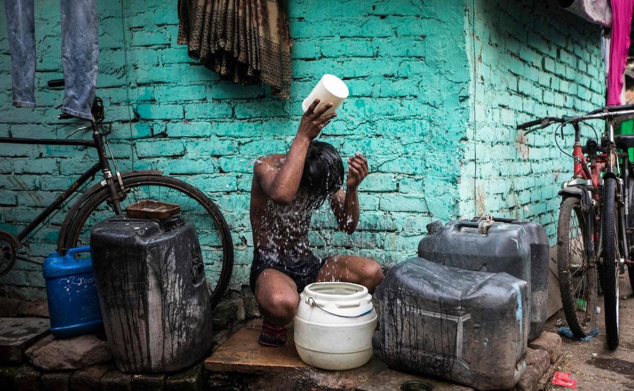 Un joven se refresca en las calles de Nueva Delhi azotada por temperaturas extremas en mayo. 