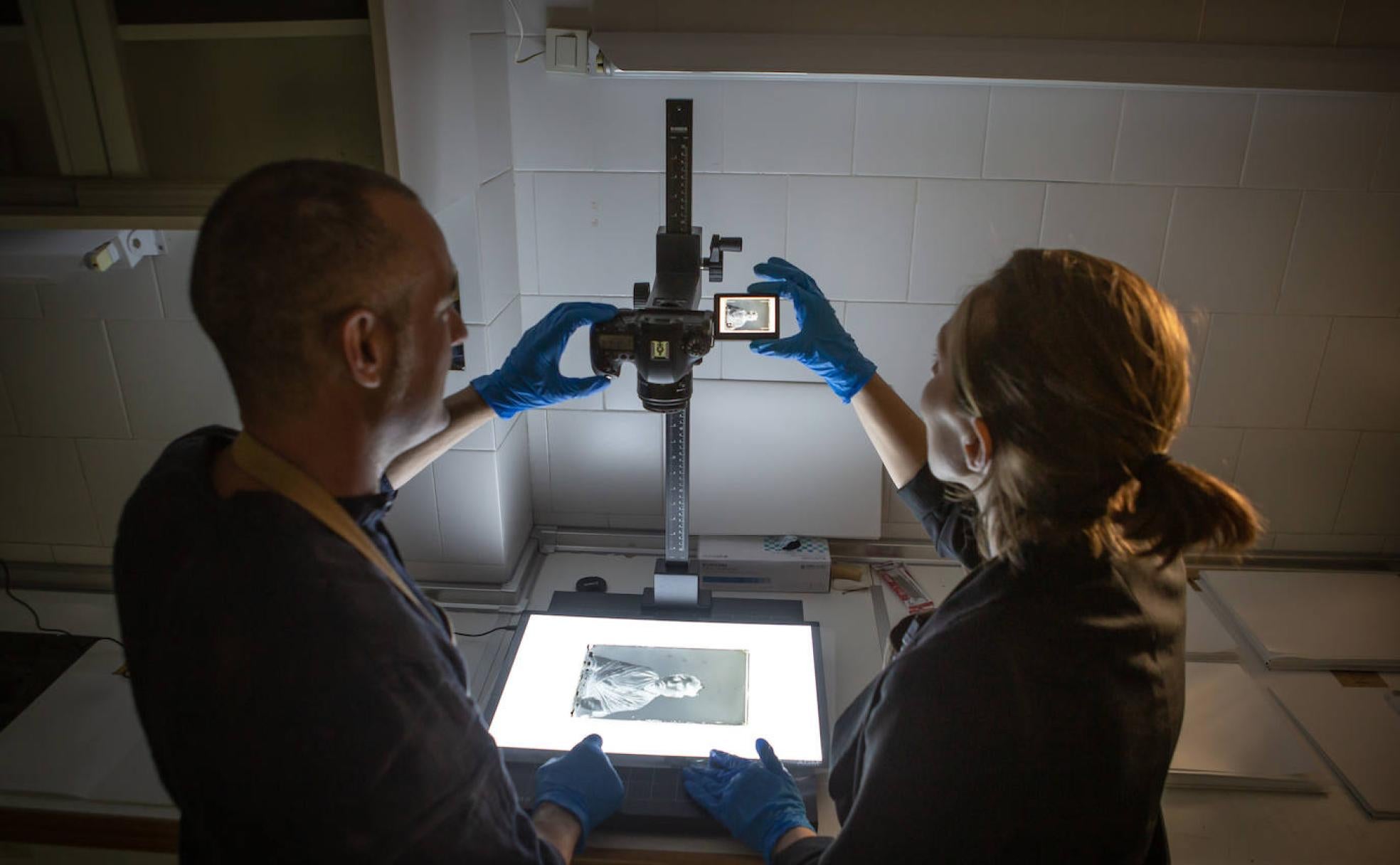 Rafael y Romina fotografían con un megatoscopio un negativo con una imagen del Chorrojumo. 