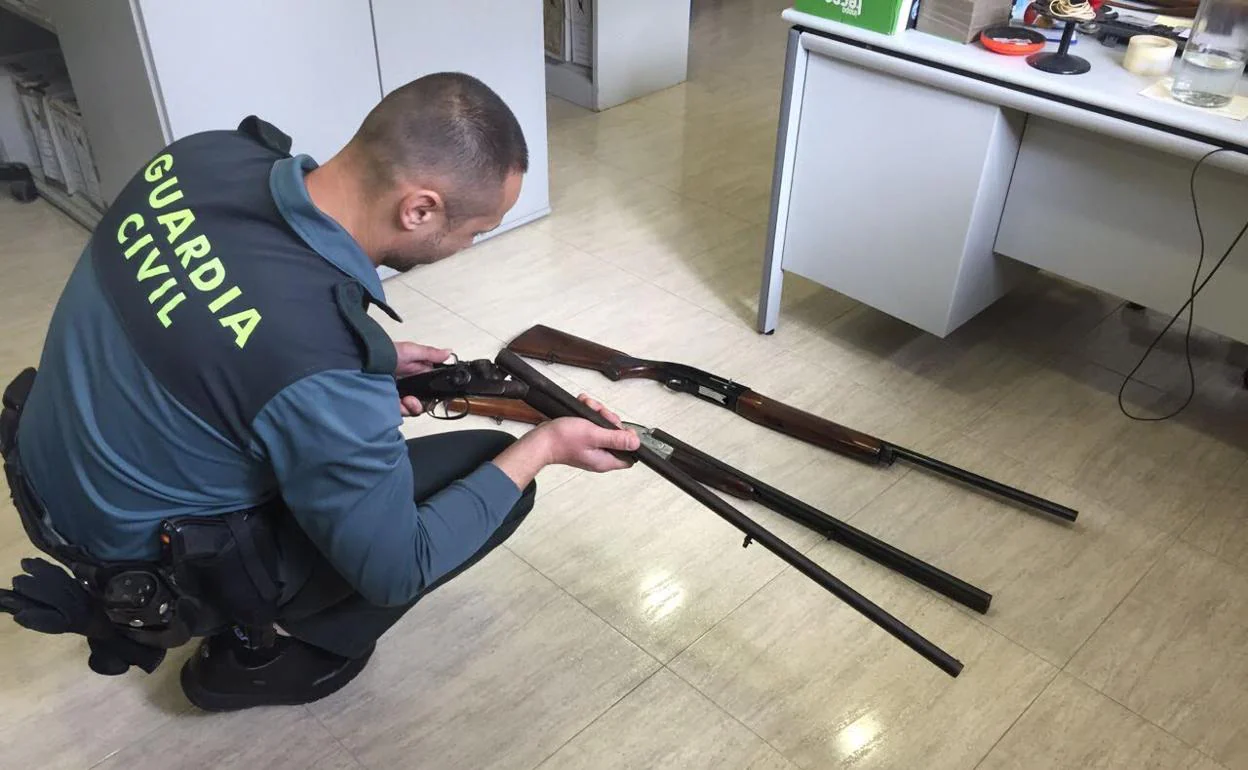 Un agente de la Guardia Civil de Granada examina unas escopetas.