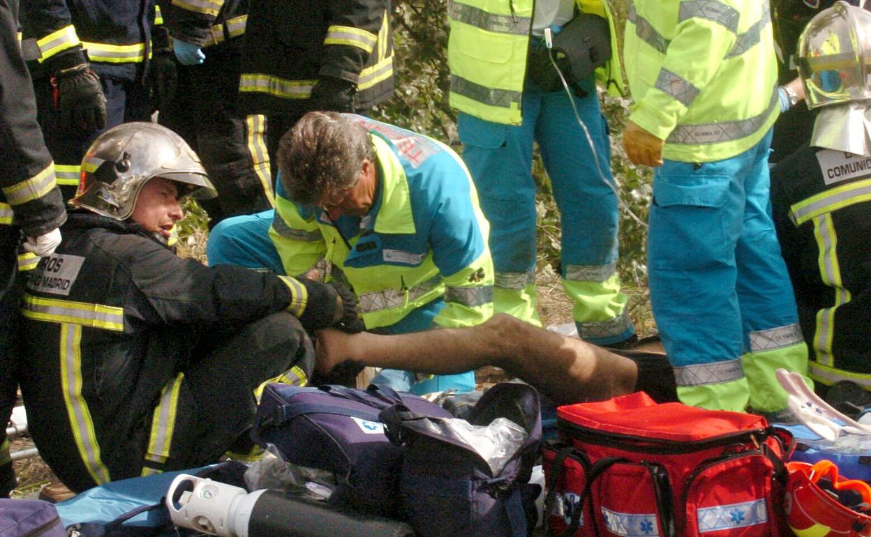 Bomberos y sanitarios atienden a un herido en accidente en Madrid. 