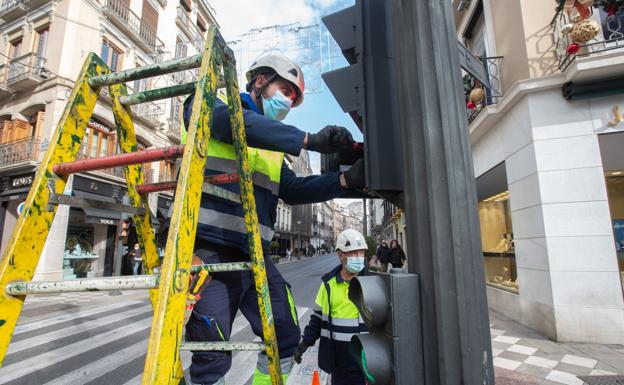 Un trabajador repara un semáforo