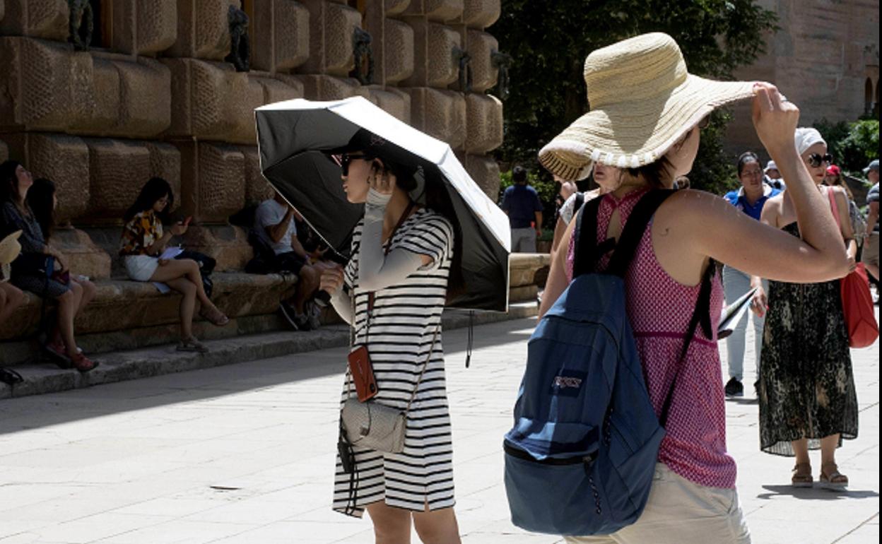 Turistas protegiéndose del sol en la Alhambra.