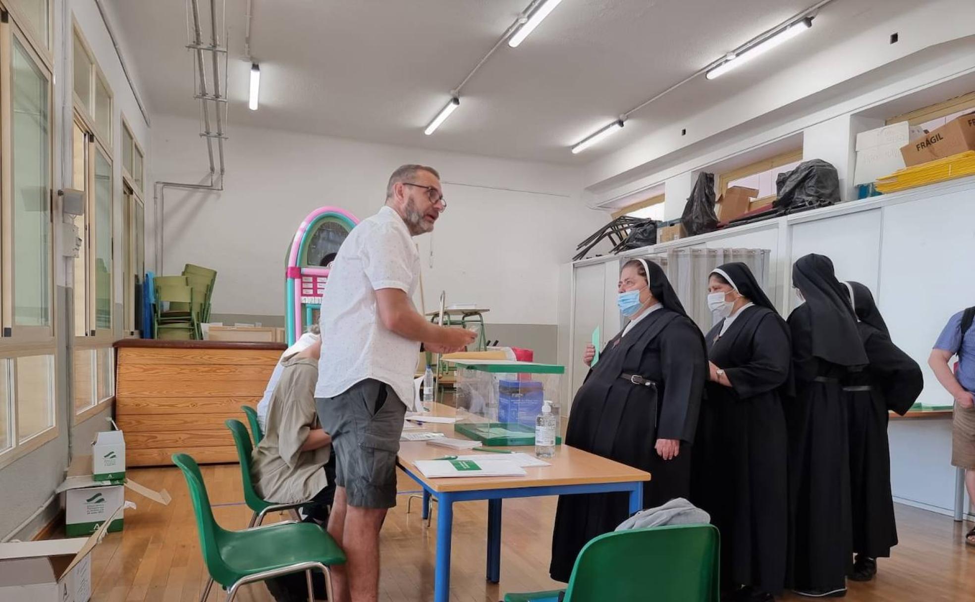 El presidente de una mesa electoral en el colegio Hurtado del Realejo atiende a unas monjas.