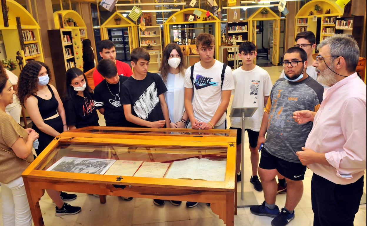 Un grupo de estudiantes linarenses visita la exposición y atiende las explicaciones de Luis Rabaneda. 