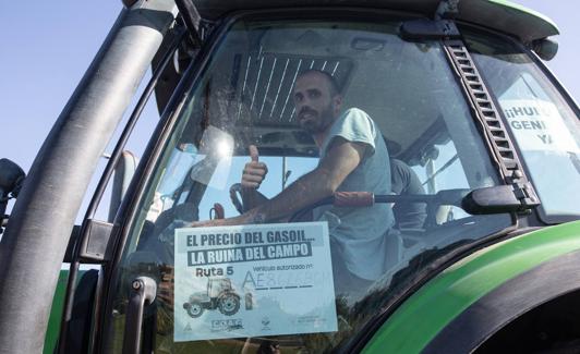 Un agricultor saluda desde su tractor en la 'tractorada' de Granada.
