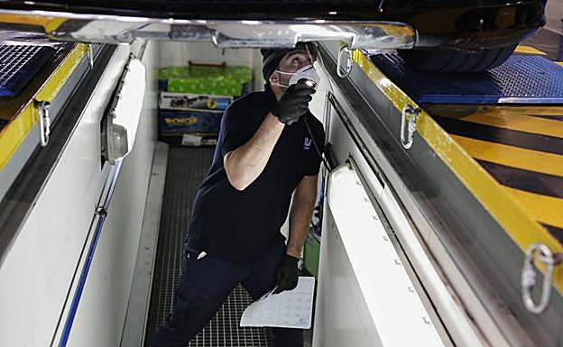 Un trabajador analiza las ruedas y la dirección de un vehículo en la ITV