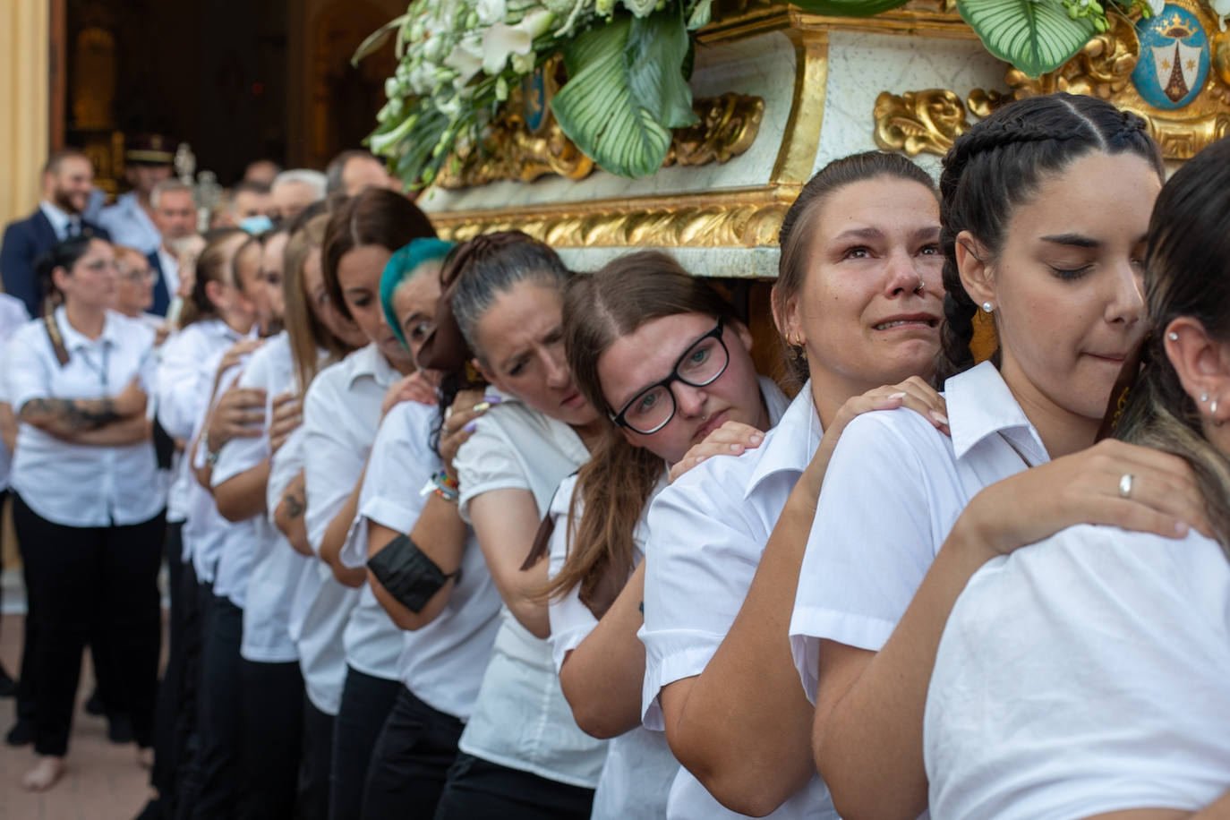 El trono de la Virgen del Carmen recibe una petalá a su paso por una de las calles de Varadero en Motril.