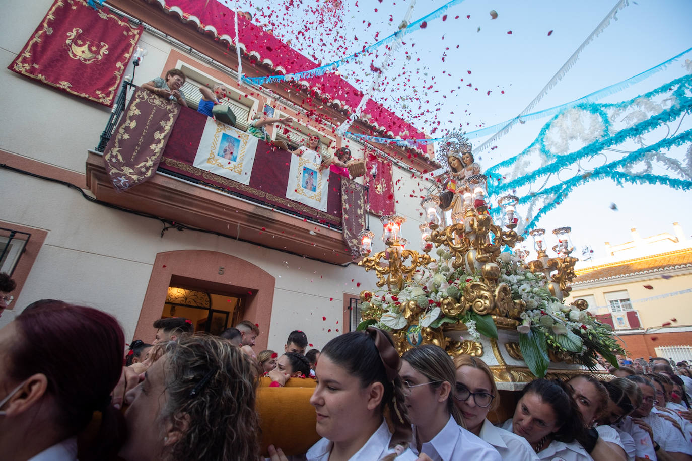 El trono de la Virgen del Carmen recibe una petalá a su paso por una de las calles de Varadero en Motril.