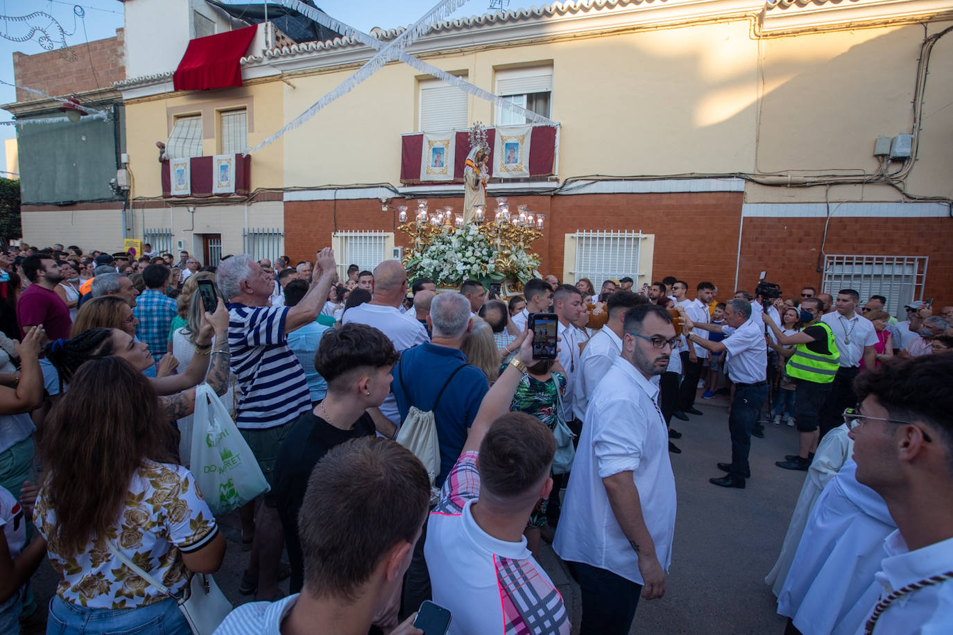 El trono de la Virgen del Carmen recibe una petalá a su paso por una de las calles de Varadero en Motril.