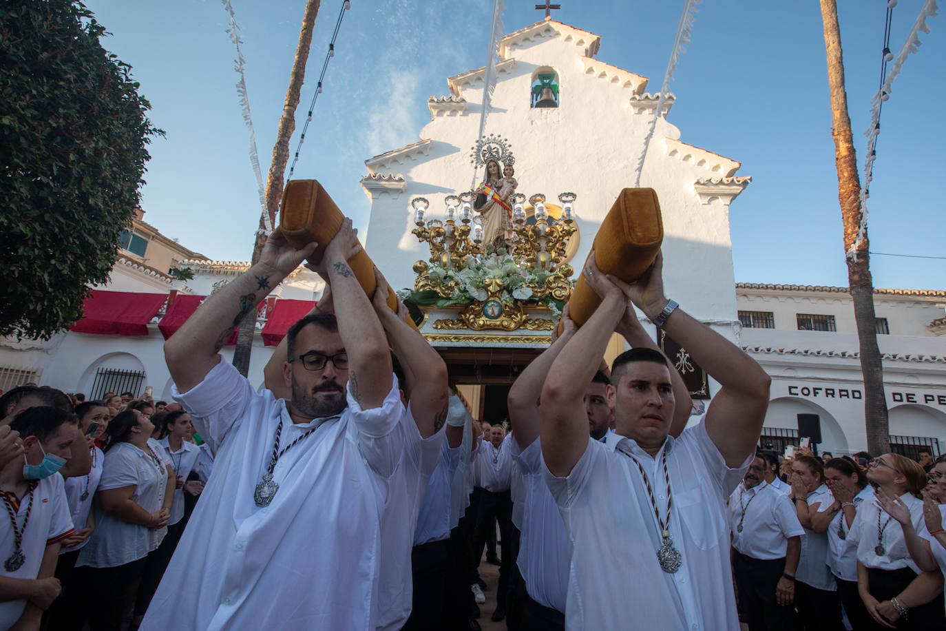 El trono de la Virgen del Carmen recibe una petalá a su paso por una de las calles de Varadero en Motril.