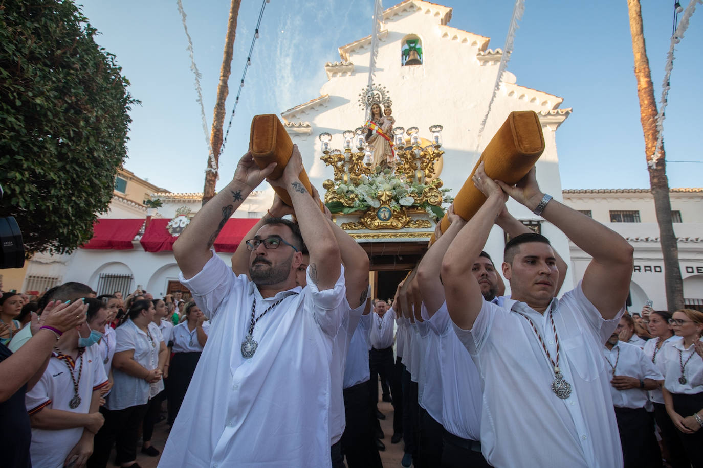 El trono de la Virgen del Carmen recibe una petalá a su paso por una de las calles de Varadero en Motril.