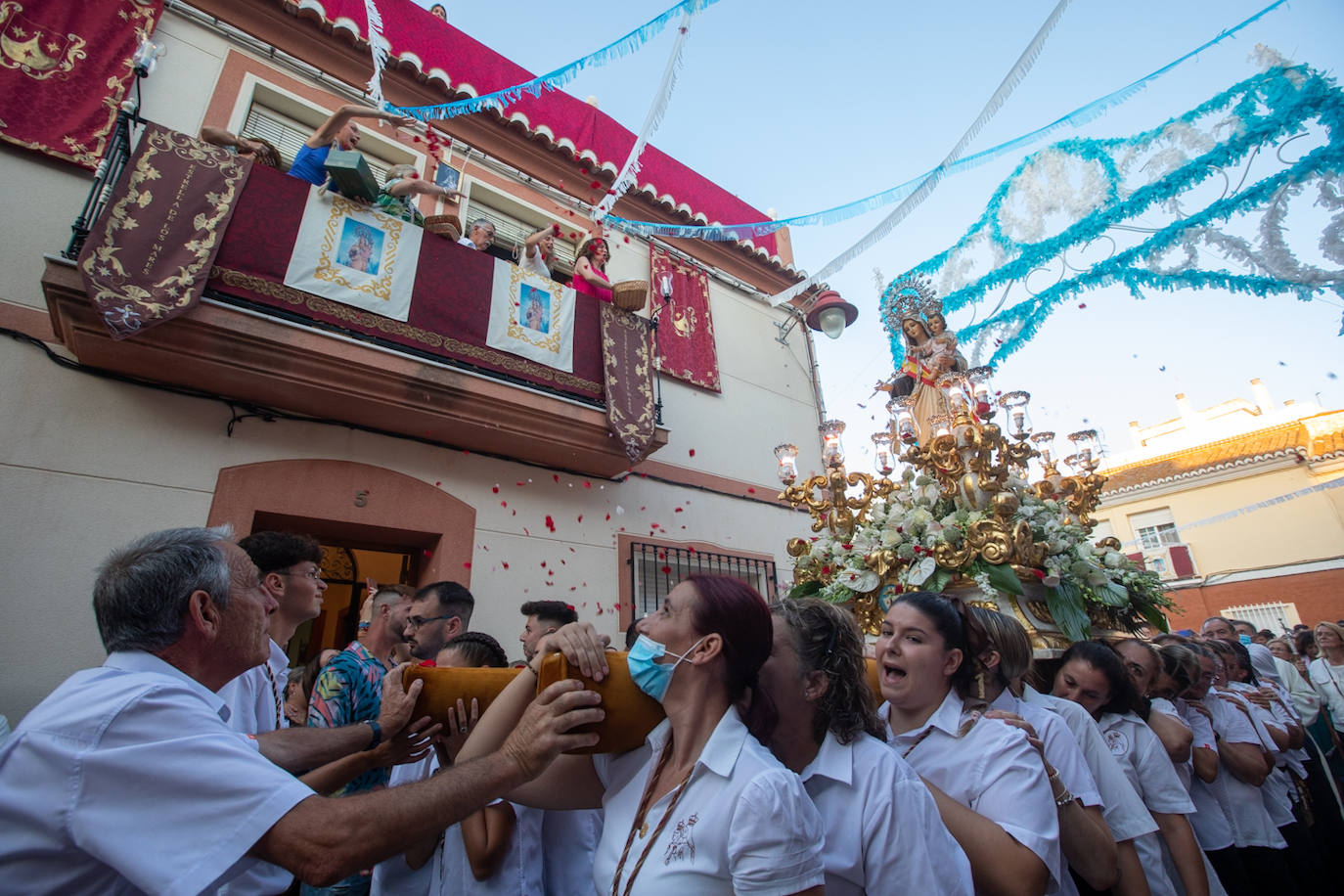 El trono de la Virgen del Carmen recibe una petalá a su paso por una de las calles de Varadero en Motril.