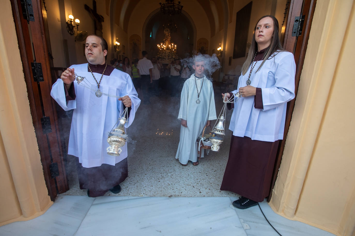 El trono de la Virgen del Carmen recibe una petalá a su paso por una de las calles de Varadero en Motril.