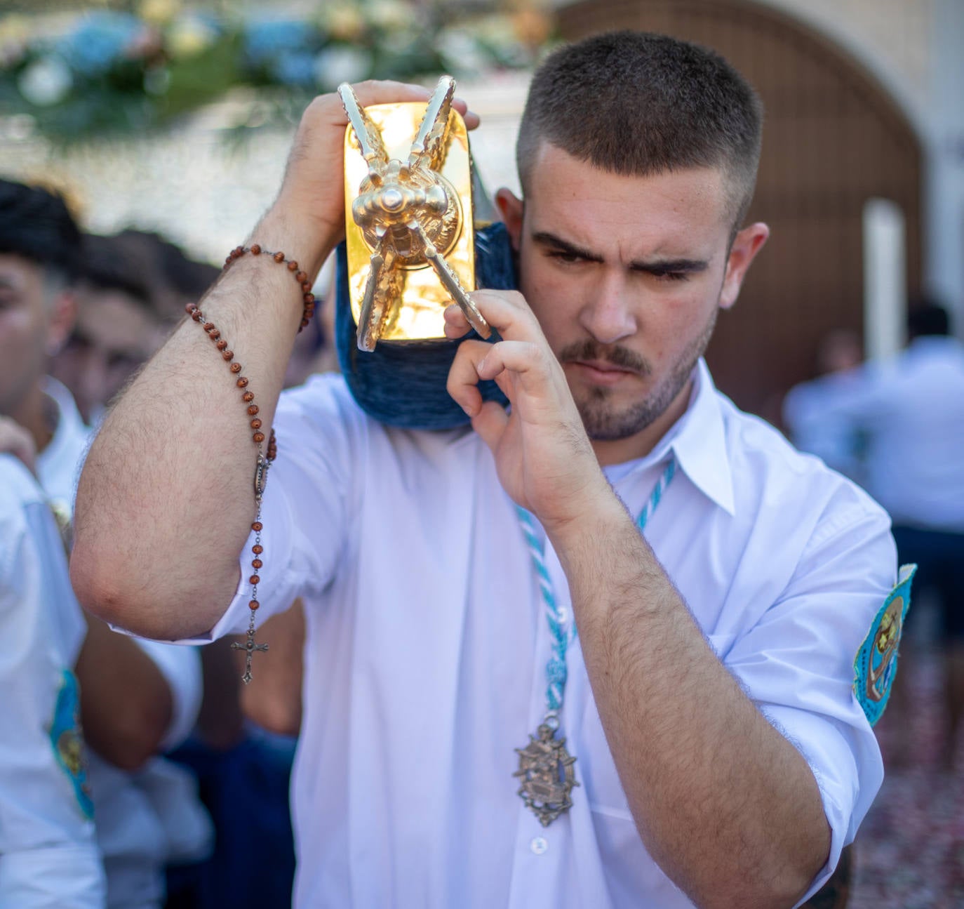 La Virgen del Carmen de Almuñéca, con el Barrio de Los Marinos al fondo, enfila la playa de San Cristóbal tras salir de la capilla.