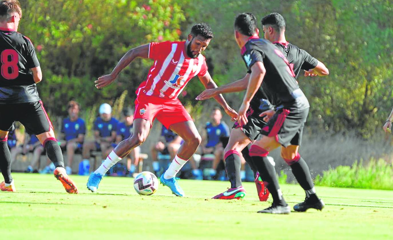 Dyego Sousa se intenta ir de una poblada defensa del Granada. 