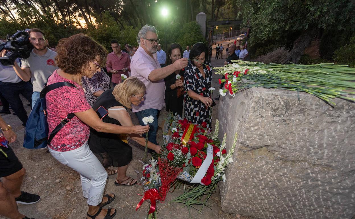 Algunos de los asistentes al acto depositan flores en el monolito que recuerda a Federico.