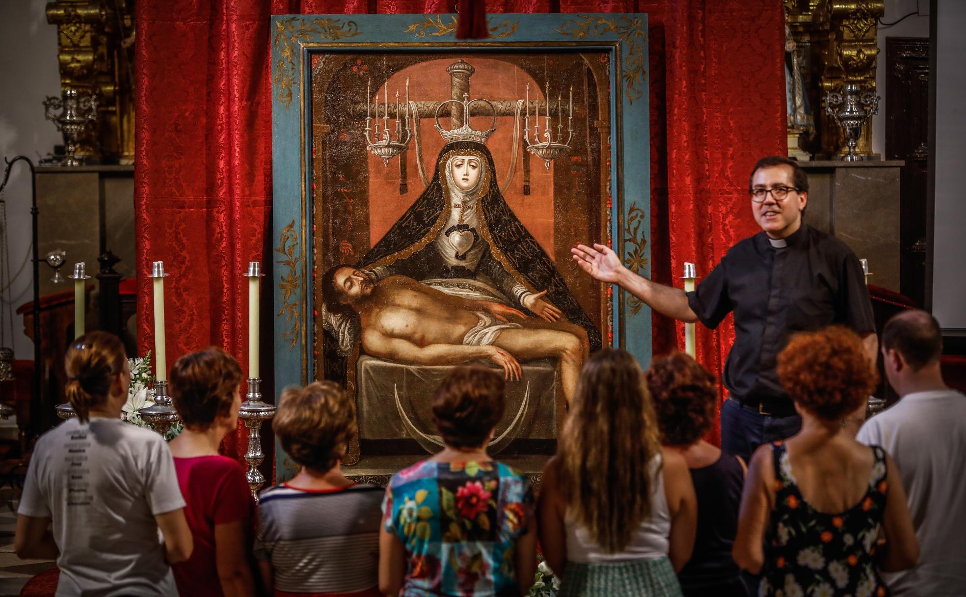 Vecinos de Víznar atienden a la explicación de David Cuerva, párroco de Víznar, sobre el cuadro de la Virgen de las Angustias, recién restaurado. 