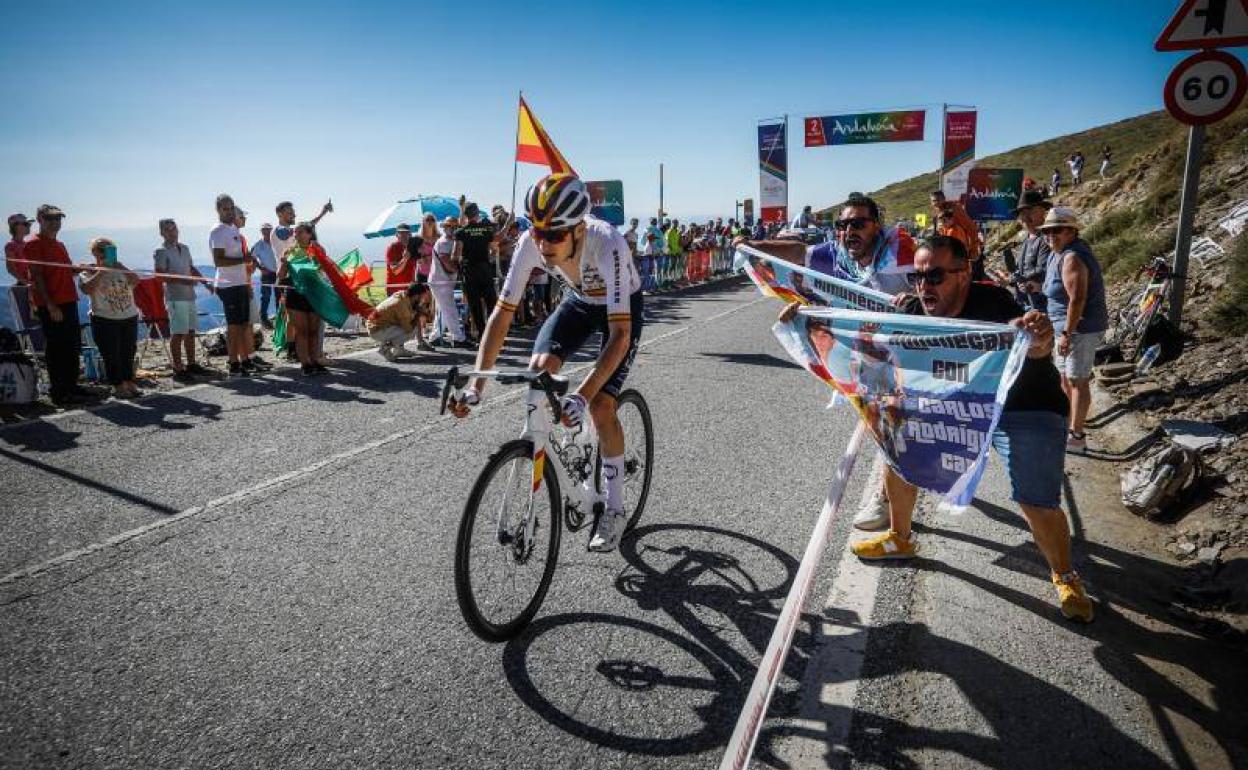 Carlos Rodríguez, espoleado por dos aficionados en pleno ascenso hacia La Hoya de la Mora. 