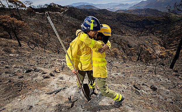 Los bomberos se funden en un abrazo. 
