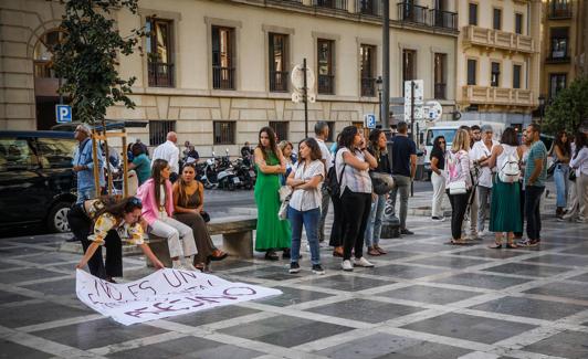Una de las amigas de la víctima coloca una pancarta en el suelo, en Plaza Nueva. 