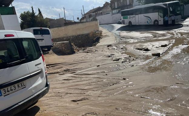 El autobús escolar de Pedro Martínez que ha quedado atrapado por la fuerte riada detenido junto al barro que ha dejado la tromba de agua en la localidad.