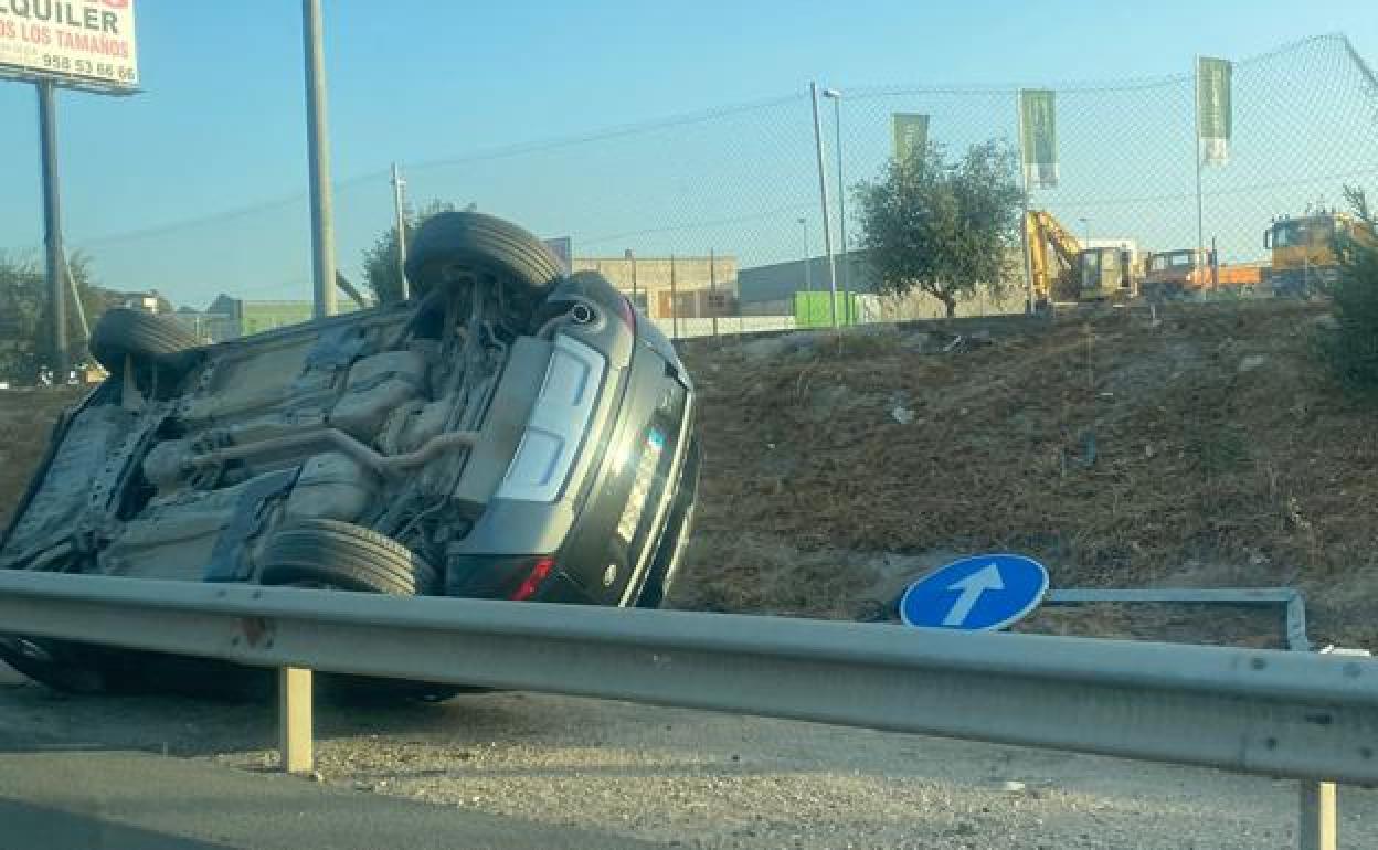 El vehículo volcado sobre la cuneta de la circunvalación de Granada.