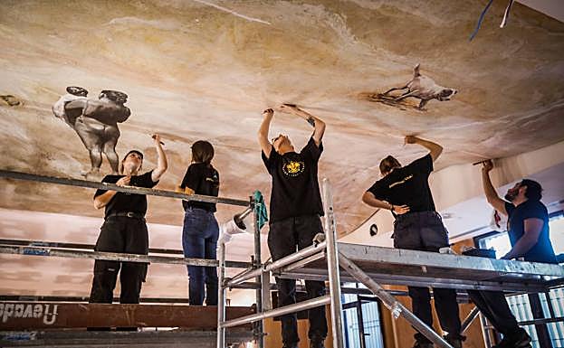 Operarios trabajando en las dos plataformas instaladas en el salón de actos del Complejo Administrativo Triunfo de la UGR. 