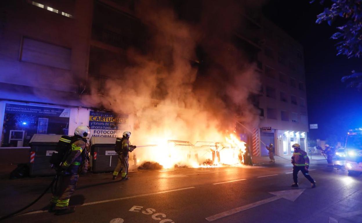 Los bomberos tratan de sofocar el incendio en los contenedores de la calle Sócrates.