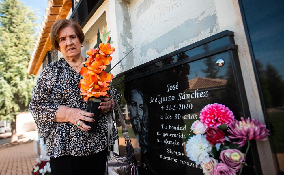 Pilar sujeta unas flores junto al nicho de José, su marido.