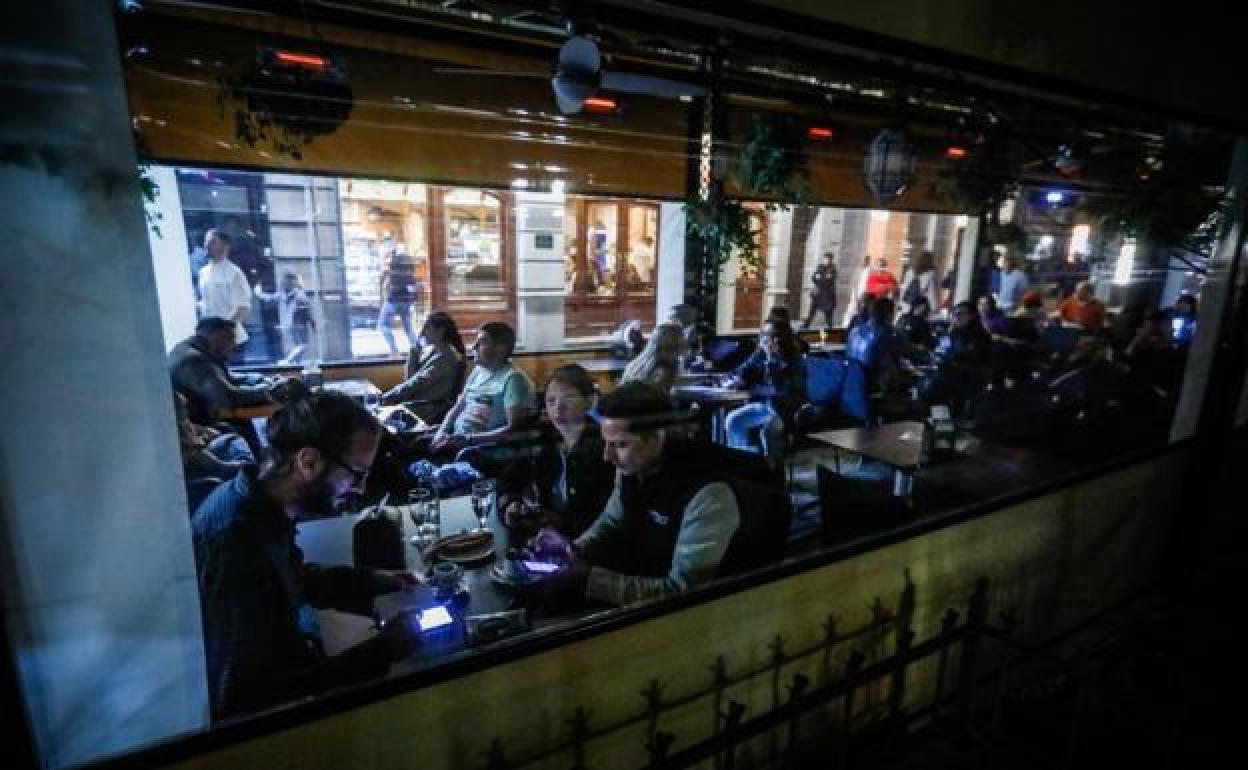 Clientes meriendan a oscuras en una cafetería de Bib Rambla.