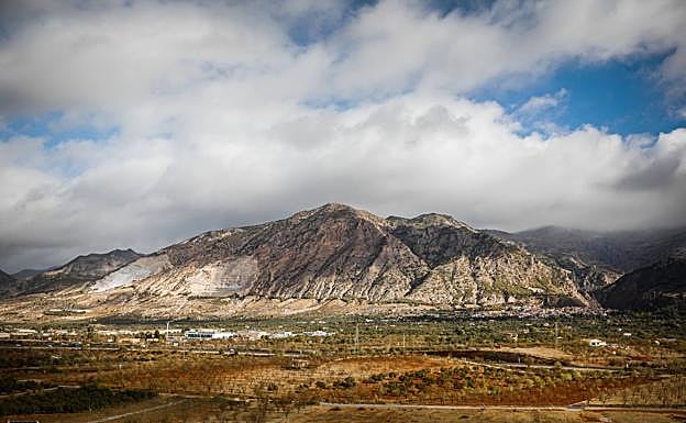 En la falda de la montaña se observa perfectamente la falla, donde hay una franja de árboles. 