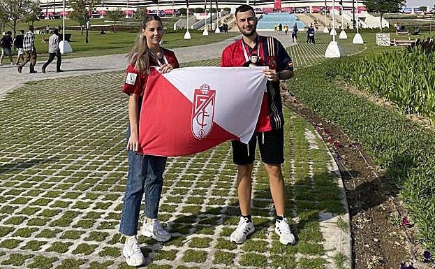 Los granadinos Andrea Barrón y Javier Illescas, pareja, en Qatar con la bandera del Granada. 