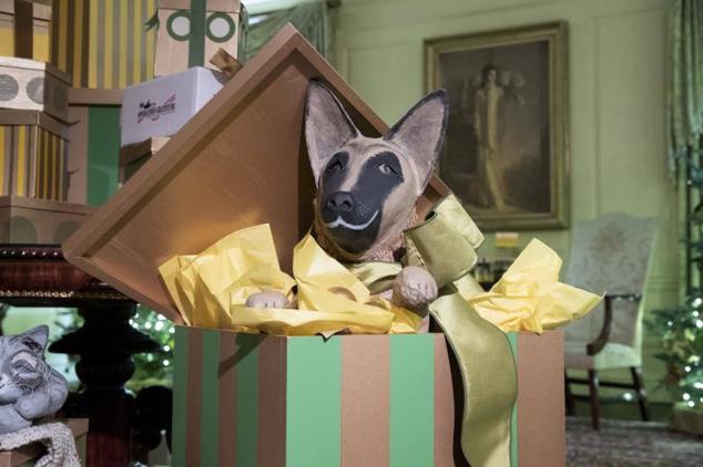 Una versión más descarada del pastor alemán de los Biden aparece en la sala Vermeil, asomándose desde una caja de regalo envuelta mientras Willow descansa cerca.
