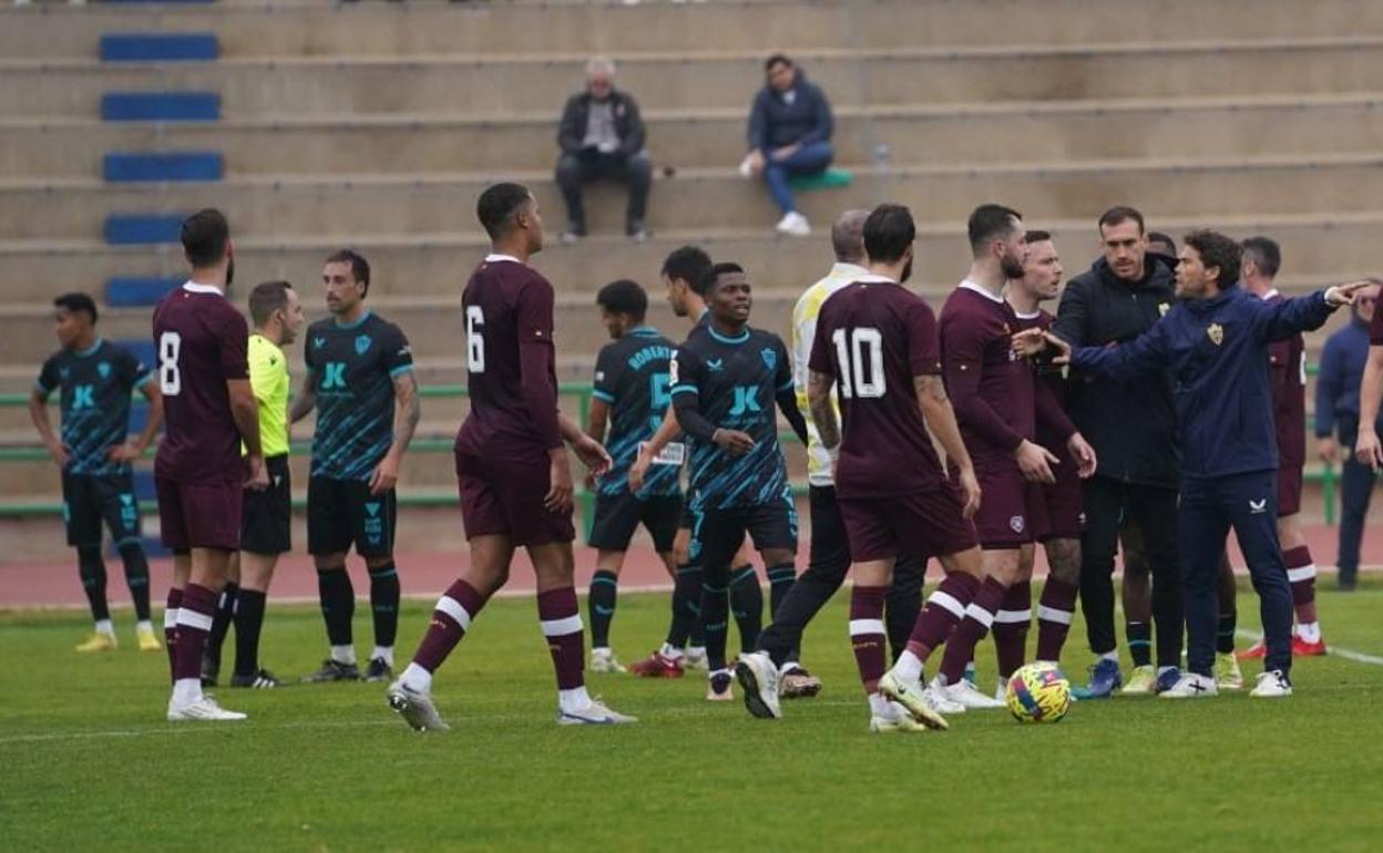 Rubi habla con dos jugadores del Hearts, antes de que estos se vayan del campo. 