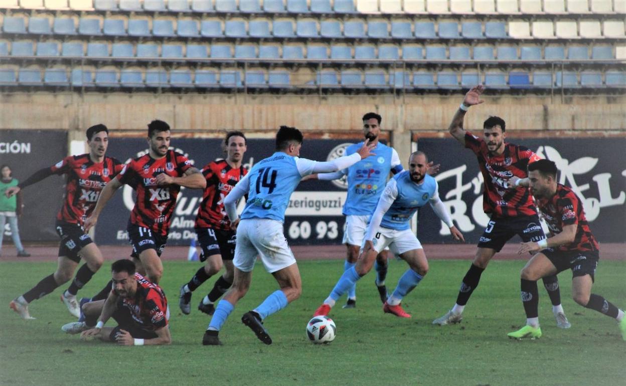 Cristóbal Moreno intenta el pase rodeado de jugadores del Yeclano. 