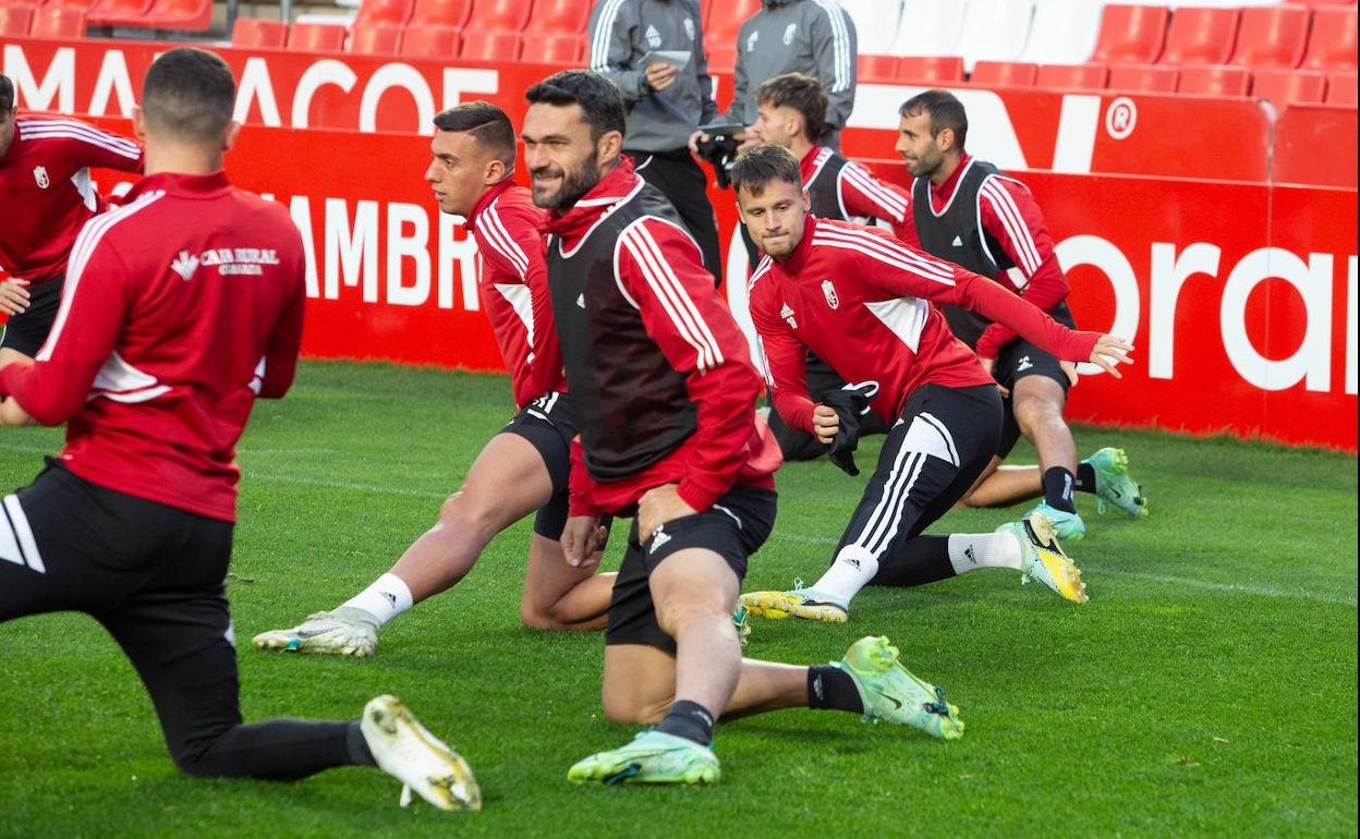 Jorge Molina y otros compañeros estiran durante un entrenamiento en Los Cármenes. 