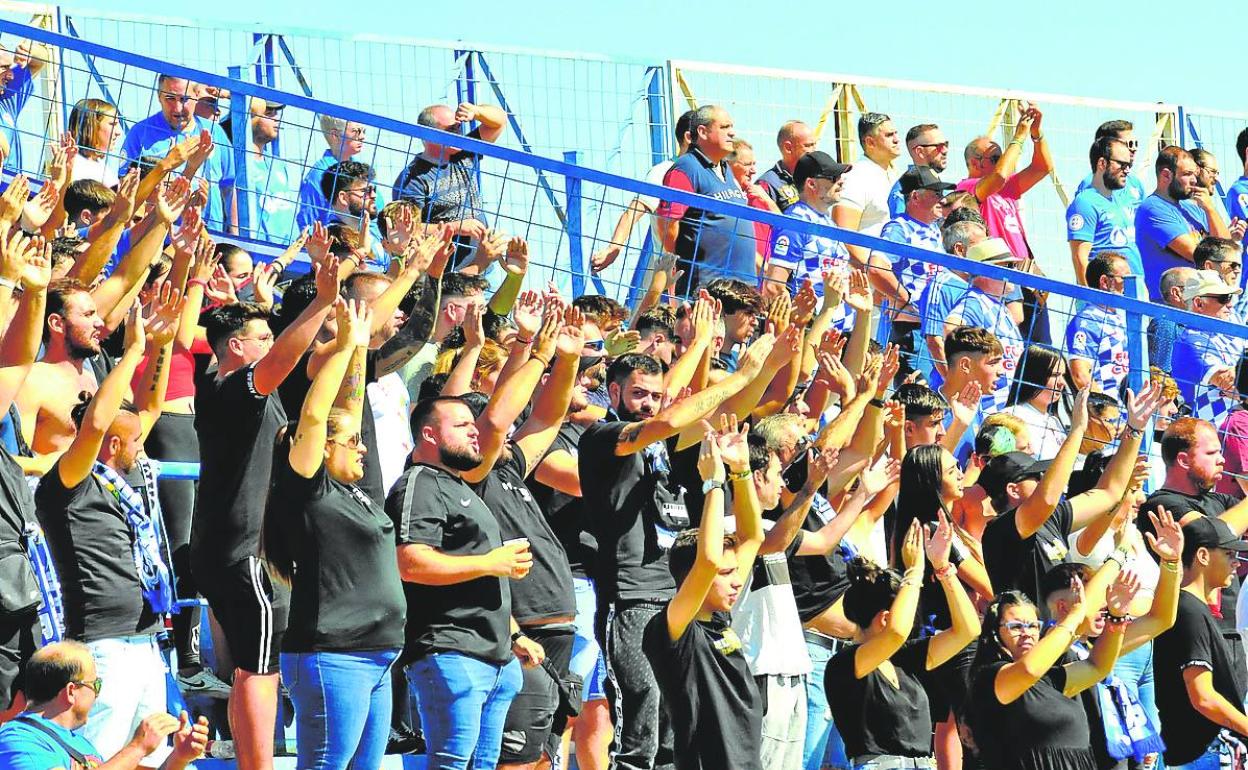 Aficionados del Linares animando en la grada durante un partido de liga. 