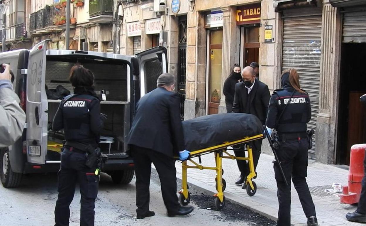 Los servicios funerarios trasladan el cadáver al coche fúnebre..