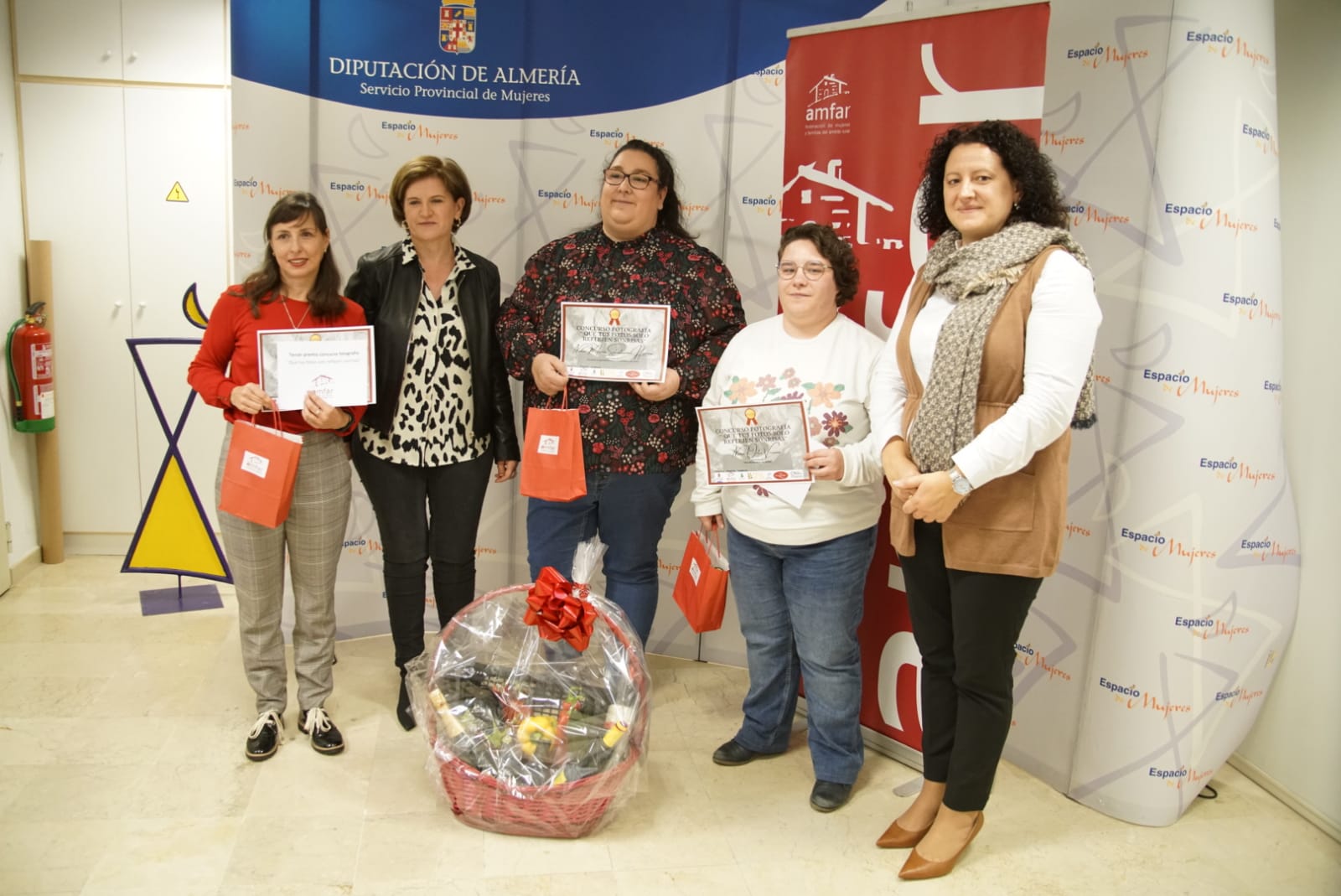 Las ganadoras del concurso fotográfico posan con sus respectivos diplomas de AMFAR. 