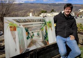 El pintor Berto Martínez posa con uno de sus cuadros en Capileira.