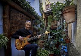 Sáez toca el bajo junto a una vivienda con profusa decoración vegetal en el casco histórico de Lanjarón.