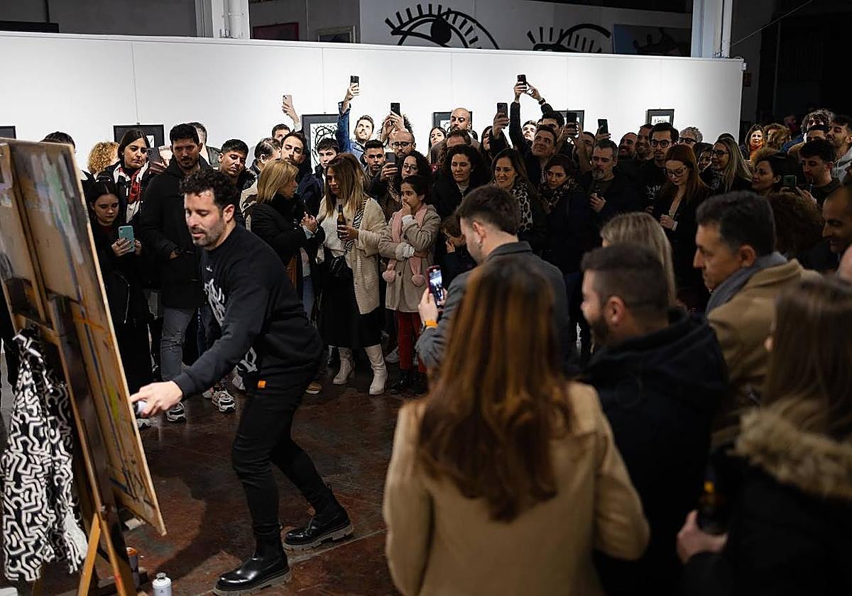 El artista linarense Miguel Ángel Belinchón 'Belin' pinta ante la atenta mirada del público.