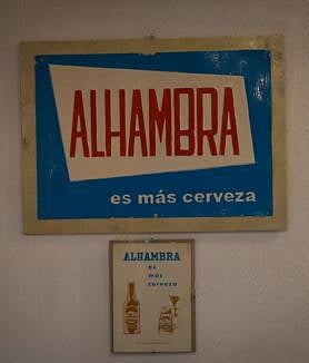 Imagen secundaria 2 - David Martínez bajando al sótano de El Boliche, la quintilla de Luis García Montero y un viejo cartel de cervezas Alhambra. 