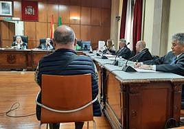 La fiscal muestra un plano de la vivienda, al fondo, y el acusado escucha su internveción.