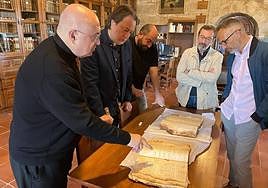 El deán de la Catedral y el concejal, a la izquierda, con los libros de los siglo XVI al XVIII.