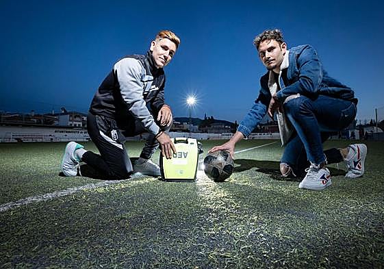 Raúl (a la derecha) y Javier (izquierda), en el lugar del suceso con el desfibrilador y el balón de fútbol.
